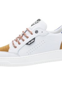 Baskets basses blanches avec embout en daim marron, lacets à motifs, côtés perforés et étiquette logo de marque sur une semelle blanche.