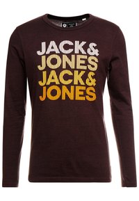 Tmavě hnědá košile s dlouhým rukávem se vzorem opakujícího se textu "JACK & JONES" v bílé, žluté a oranžové vertikální pruže na přední straně.