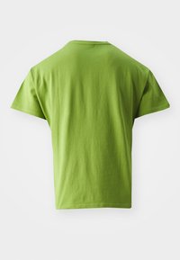 Zeleno bombažno majico s sproščenim krojem, kratkimi rokavi in okroglo ovratnikom. Gladka tekstura in brez vidnih vzorcev ali dodatkov.