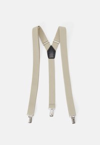 Tirantes de tela beige con dos clips plateados, diseño en forma de Y y un acento de cuero negro en el centro. Textura suave y construcción robusta.