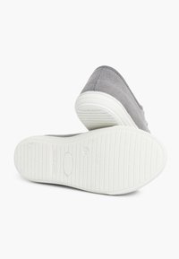 Halli halli slip-on kingad hallist kangast, valgete kummitaldadega, sujuva tekstuuri ja peente õmblusdetailidega.