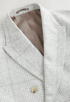 Blazer texturizado en gris claro con cuello de muesca, que presenta un cierre de un solo botón y un forro interior suave en beige.