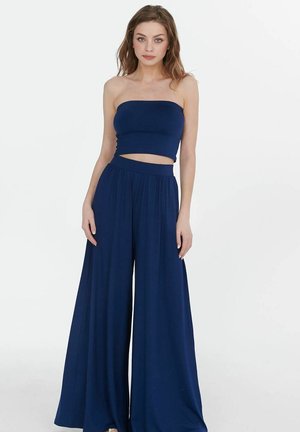 Námořnický dvoudílný outfit obsahující top bez ramínek a kalhoty širokého střihu. Hladký materiál se volným střihem a elastickým pasem.