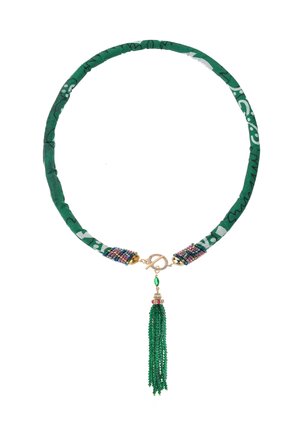 Collier en tissu vert avec des accents en perles, des accessoires en or et un pendentif en franges vertes. Le design présente un bandeau en tissu à motifs.
