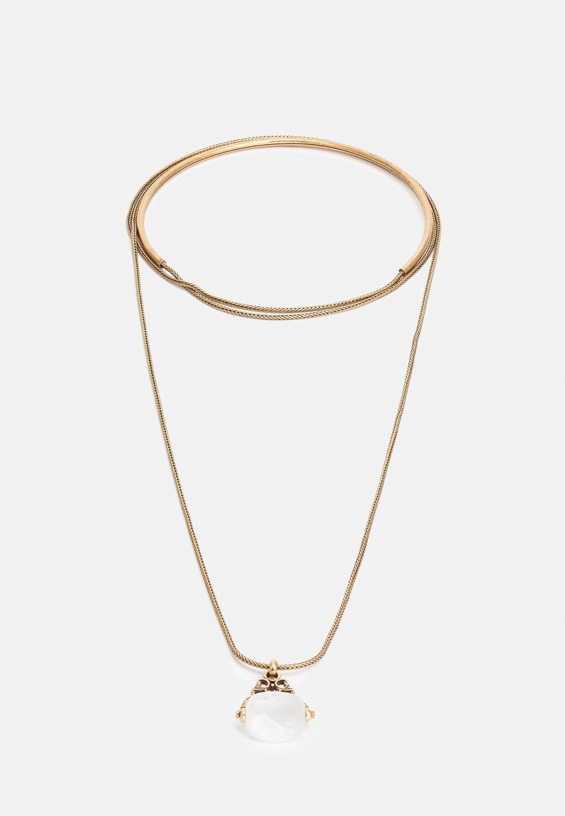 Collier en or avec une chaîne fine et un sertissage orné tenant un pendentif en pierre précieuse ronde et transparente sur fond blanc.