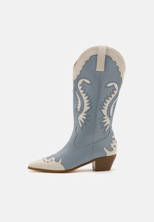 Blue leather cowboy boot with a pointed toe, white accents, and decorative stitching. Features a low stacked heel and a scalloped top.