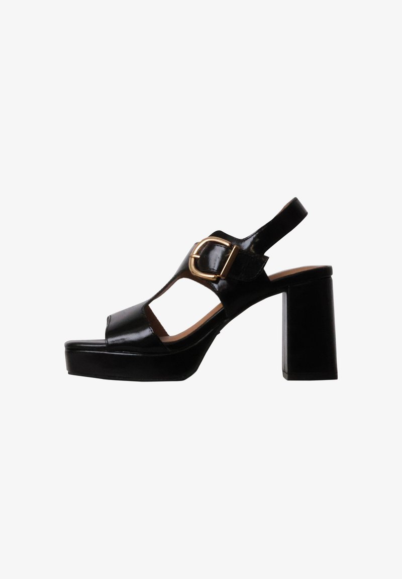Sandale à talon bloc en cuir verni noir avec bout ouvert, côtés ouverts et une grande boucle dorée sur la bride de cheville.