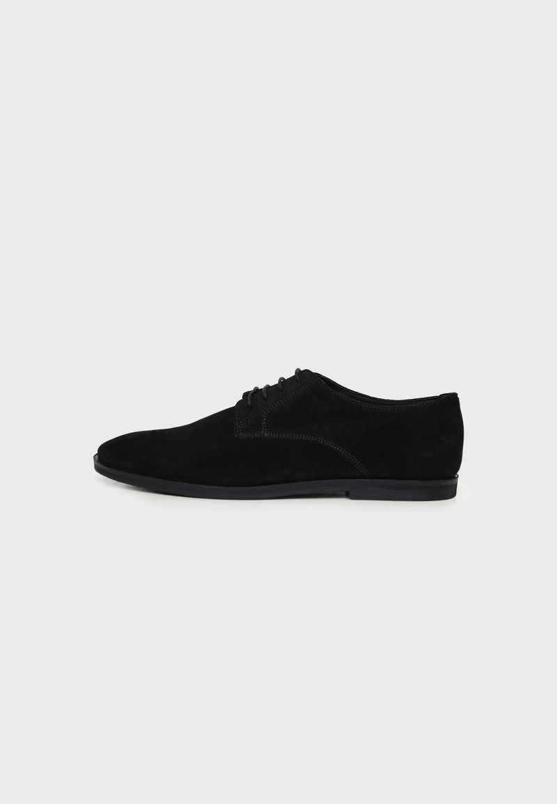 Chaussure habillée pour homme en daim noir à lacets, talon bas et bout arrondi, montrée de profil sur fond blanc.