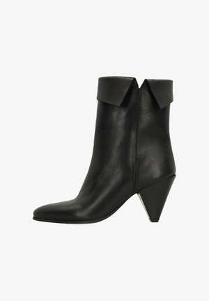 Botte cheville en cuir noir avec revers replié, bout pointu et talon conique incliné, vue de l'extérieur.