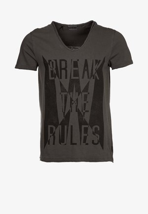 Harmaa puuvillainen t-paita, jossa v-kaula-aukko, lyhyet hihat ja etupuolella isolla mustalla tekstillä "RIKO SÄÄNNÖT". Kankaassa on tekstuuri.