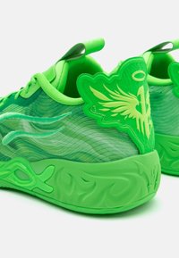 Grønne joggesko med et teksturert mesh-overdel med virvlende mønstre, formede detaljer ved hælen, og en tykk såle med detaljert design.