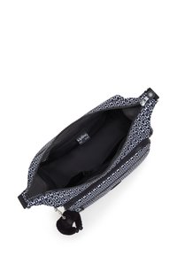 Bolso bandolera de patrón en blanco y negro con cremallera superior abierta, forro interior negro, bolsillo lateral con cremallera y un pequeño charm negro en forma de llavero.