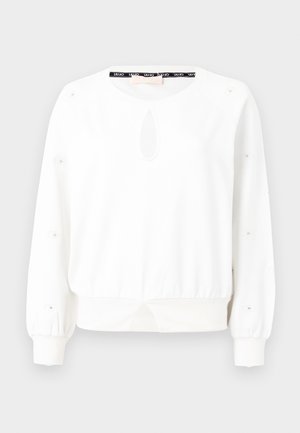 Felpa bianca con colletto rotondo, dettaglio a chiave sul davanti e accenti a bottoni sulle maniche. Presenta una vita arricciata e polsini a costine.