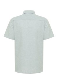 Koszulka z krótkim rękawem w jasnoszarym kolorze, wykonana z fakturowanej tkaniny, z kołnierzykiem i prostym tylnym dołem. Brak widocznych wzorów lub detali metalowych.