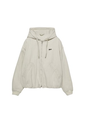 Svijetlosmeđi zip-up dukserica s prednjim džepom, kapuljačom s vezicom, rebrastim manžetama i malim crnim logotipom na lijevoj strani prsnog koša. Mekana tkanina.