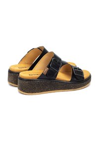 Sandalias de cuero negro con dos correas anchas, hebillas ajustables y una suela de plataforma similar al corcho. La suave plantilla color tostado aporta comodidad.