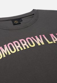 Gray cotton t-shirt featuring gradient yellow to pink lettering spelling "TOMORROWLAND." Round neckline with black tag inside. Soft texture.