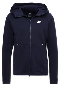 Marinblå zip-up hoodie i mjukt material, med en stor huva, två framfickor och en vit Nike-logga på bröstet.