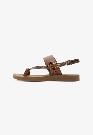 Sandales en cuir marron avec un dessus lisse, deux sangles réglables et une accent texturé. La semelle est plate et marron clair.