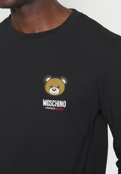 Black long-sleeve t-shirt featuring a cartoon bear logo in brown with white and red text "MOSCHINO UNDERBEAR" below the design. Cotton material.