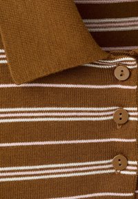 Polo en maille marron avec des rayures horizontales blanches et rose clair et trois boutons marron sur la patte de boutonnage devant.