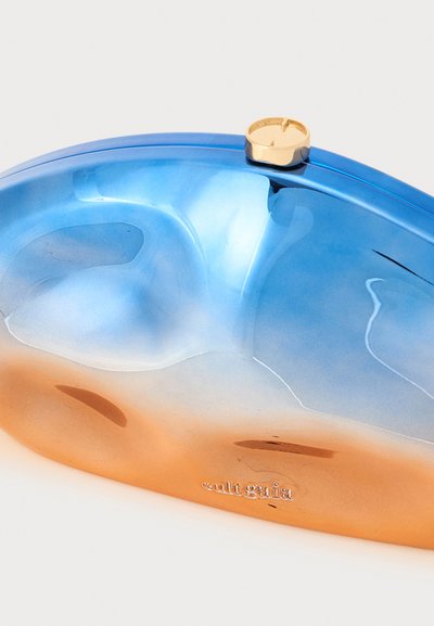 Un bolso de mano curvado en un degradado de azul a naranja de acrílico, con un cierre dorado. La superficie tiene un acabado brillante y una textura suave.