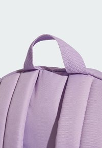 Paarse rugzak van textiel, met een kort handvat en een gevoerd ontwerp. Het materiaal lijkt duurzaam, met nette stiksels en plooien.
