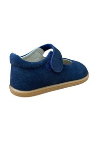 Zapato de ante azul marino con una correa de velcro, punta redonda y suela de goma beige. Presenta un diseño en forma de corte en la parte superior para mayor detalle.