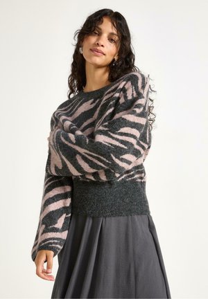 Let svag, strikket sweater med en mørkegrøn bund, prydet med et pink og sort zebra-stribemønster, samt en ribbet kant. Lange ærmer.