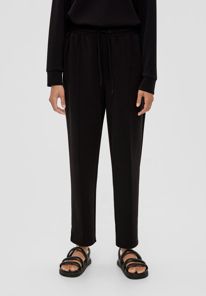 Zwarte taps toelopende sweatpants van zachte stof met een elastische tailleband met trekkoord, zijzakken en een gladde textuur.