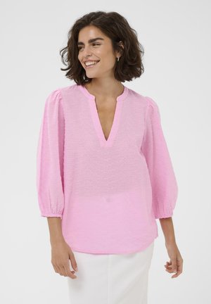 Pink textured blouse with a V-neck, 3/4 puff sleeves, and elastic cuffs. The fabric has a subtle stripe pattern, enhancing its visual interest.