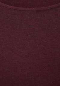 Bordo pleteni materijal s finom rebrastom teksturom. Glatka površina i široki izrez, prikladan za slojevito nošenje ili kao samostalni komad.
