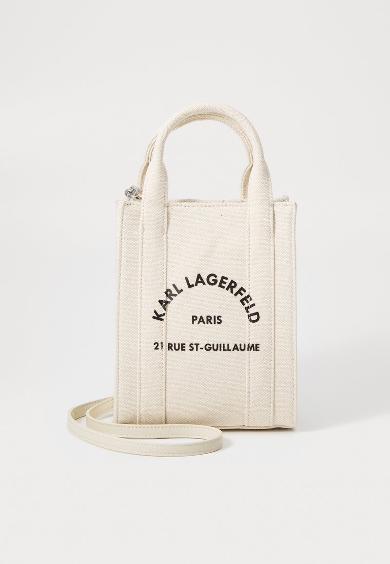 Borsa in tela off-white con doppio manico superiore e tracolla removibile, caratterizzata da testo stampato in nero. Forma rettangolare.