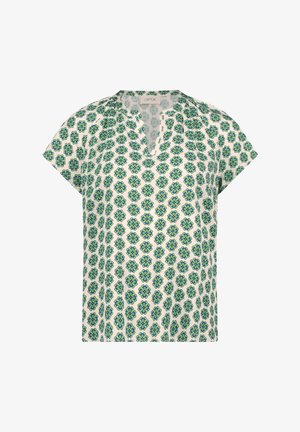 Valkoinen lyhythihainen pusero, jossa on sinivihreä kukkakuvio ja pieni V-kaula-aukko kauluksessa.