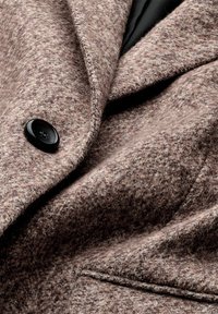 Bruine gestructureerde wolmixjas met een zwarte satijnen voering, notch-lapels en een enkele zwarte knoopdetail.