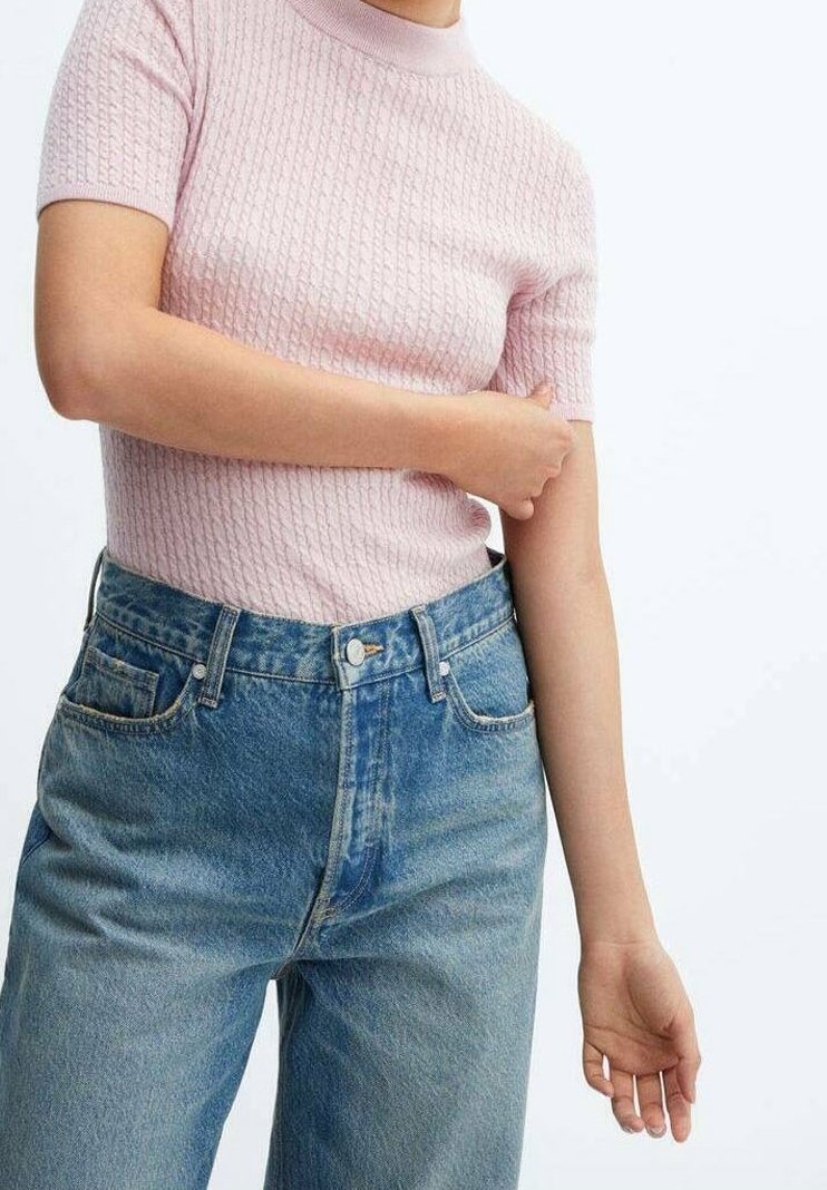 Haut en tricot côtelé rose clair à manches courtes, associé à un jean en denim bleu délavé taille haute. Montre une texture douce et un design classique.