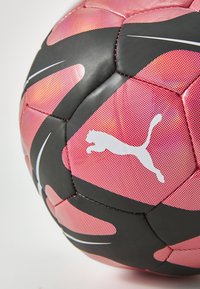 Sort og lyserød fodbold med en struktureret overflade, der har et hvidt Puma-logo og geometrisk mønster, syede sømme og buede accentlinjer.