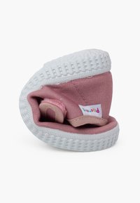 Zapatilla de lona rosa con suela de goma blanca, diseñada para parecer doblada. Incluye un forro suave y una pequeña etiqueta de tela para la marca.