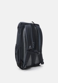 Sac à dos en tissu gris foncé, avec des bretelles en mesh rembourrées, des poches latérales et une poignée sur le dessus. Des contours lisses offrent une forme ergonomique.