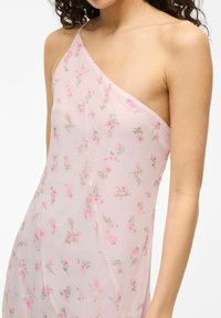 Light pink dress with an asymmetrical design, featuring floral patterns in pink and green on sheer fabric and a single shoulder strap.