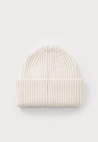 Beanie tricotat de culoare crem, cu o textură cu nervuri. Prezintă o margine pliată și o coroană superioară alungită pentru un plus de căldură.