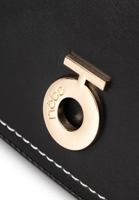 Borsa a tracolla in pelle nera con un accento circolare in metallo dorato con il nome del marchio "nōbo", completata da dettagli di cuciture bianche.