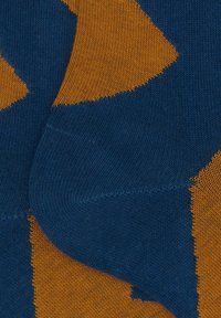 Calzini lavorati a maglia con un motivo di forme blu e arancioni, con texture a coste e colori a contrasto. Finitura liscia nel complesso.