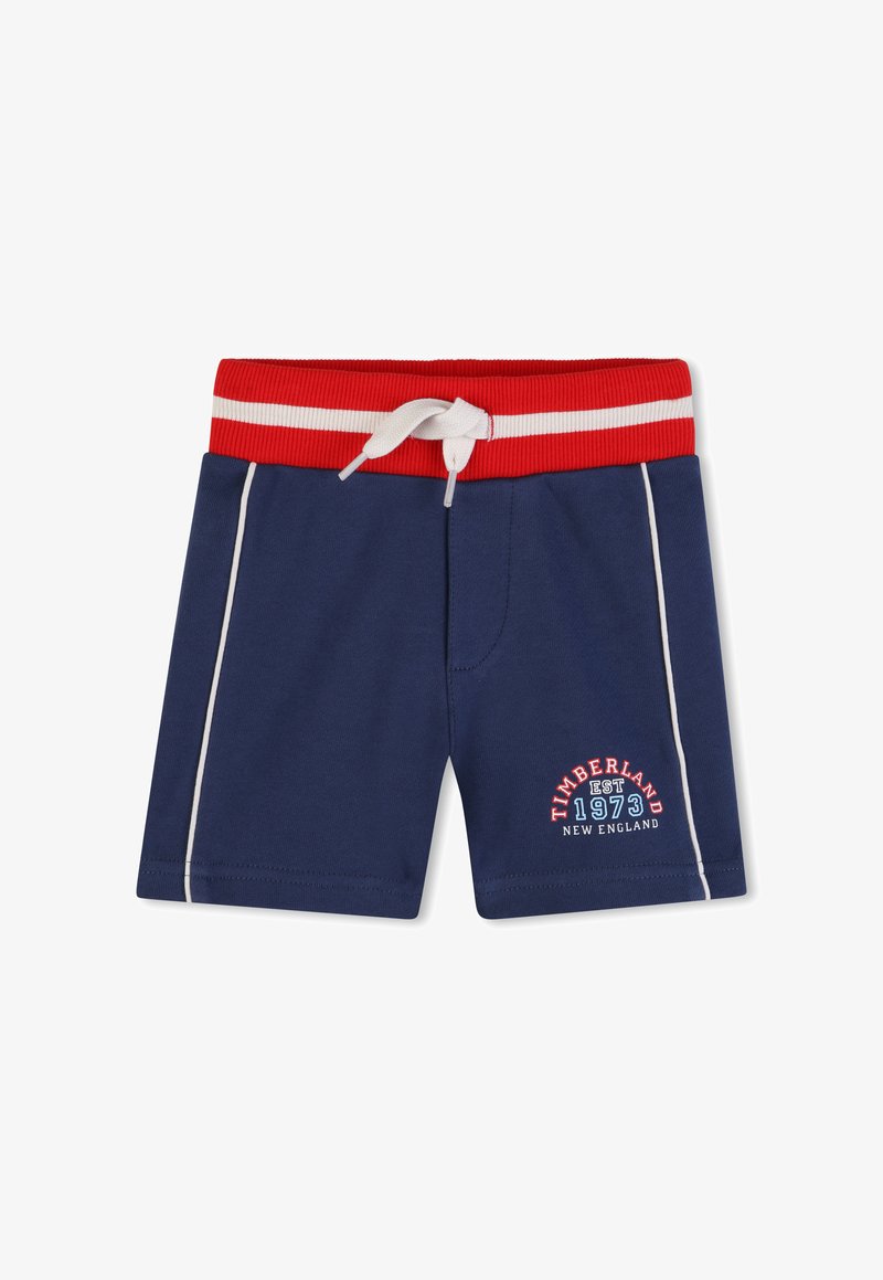 Shorts pour tout-petit bleu marine avec taille élastique rouge, cordon de serrage blanc, bandes latérales blanches et logo Timberland 1973 New England sur la jambe.