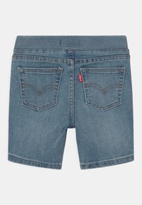 Jeanshort met een medium blauwe tint, elastische tailleband, twee achterzakken met stikdetails en een subtiele vervaagde textuur.