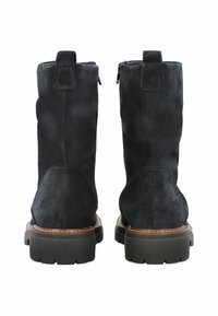 Mustat mokkanahkasaappaat nilkkamitassa, joissa on kaareva muoto, sivuvetoketju, vetotappi ja paksu kumipohja, jossa on teksturoitu kuvio.