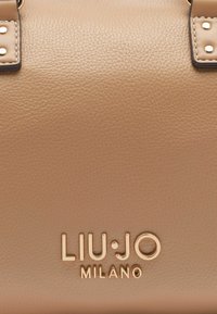 Beige kožená kabelka s zlatými prvky, texturovaným povrchem a embosovaným logem "LIU•JO MILANO" na přední straně.