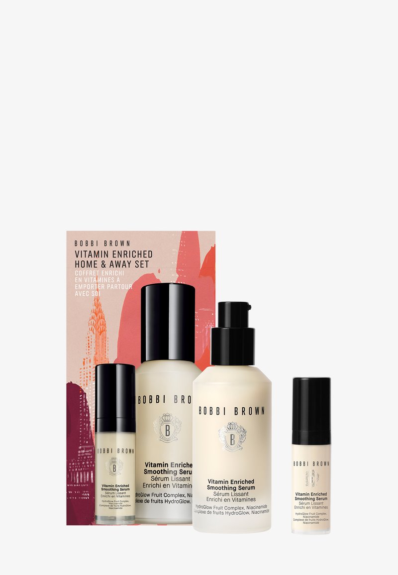 Vitaminerik Hjem & Borte Sett med tre flasker i ulike størrelser. Klare og dempede kremfargede beholdere med svarte topper, pakket i eske med fargerik design.