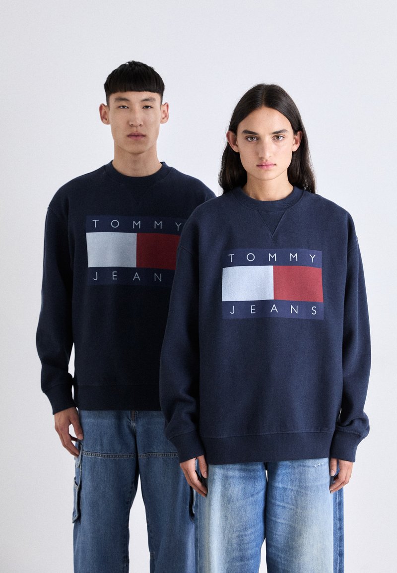 Námorníckomodré mikiny s grafickými blokmi s textom "TOMMY JEANS" v bielej, červenej a modrej farbe, so ribovanými manžetami a vo voľnom strihu.