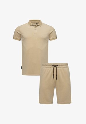 Beige polo skjorte med korte ermer, med en treknappslukking og en merkelapp på siden. Matchende beige shorts med elastisk liv og snor.